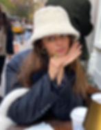 A beautiful female model wearing an off-white color fuzzy bucket hat