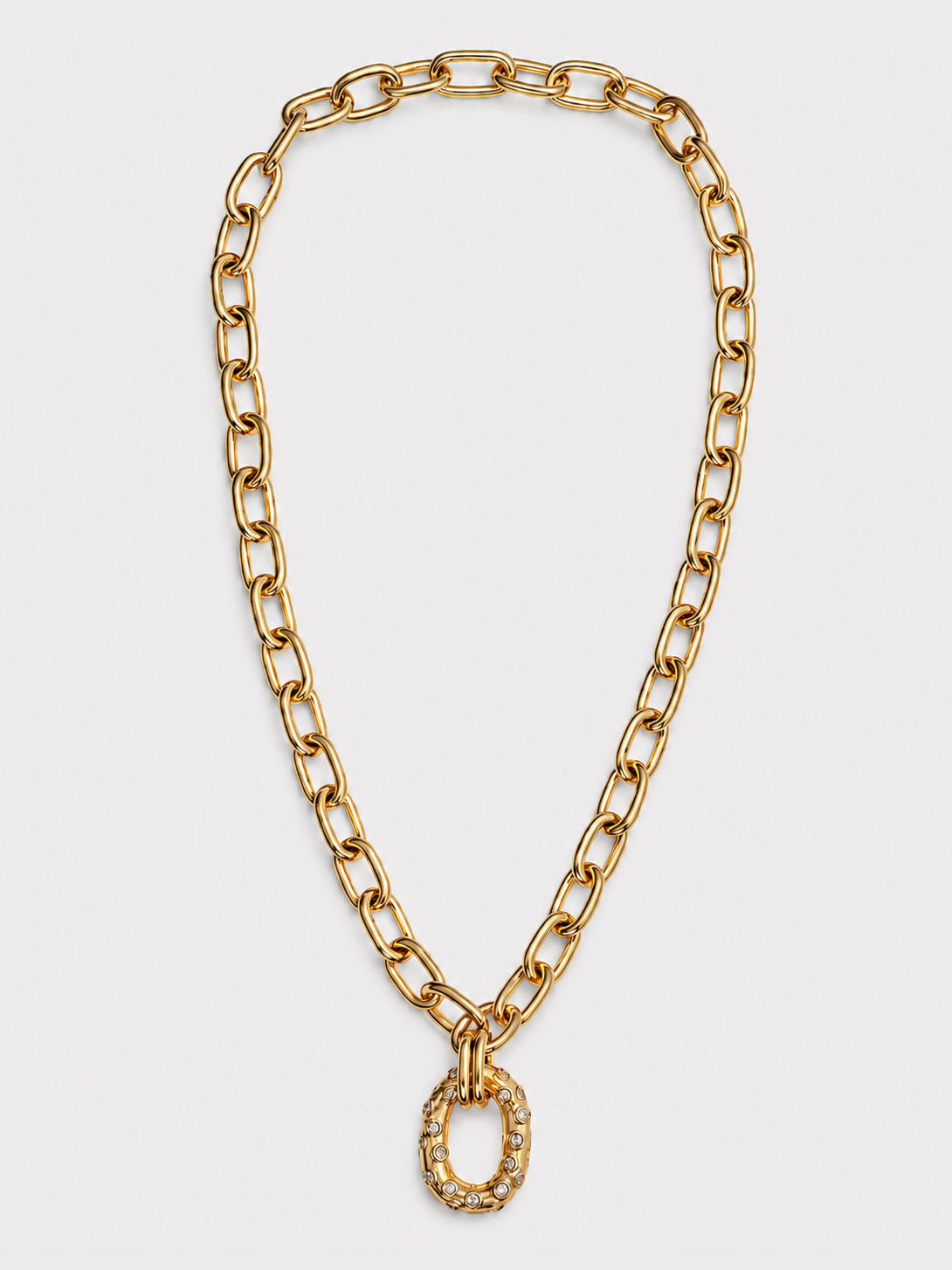 Chunky gold chain necklace with a clear stone-set oval pendant