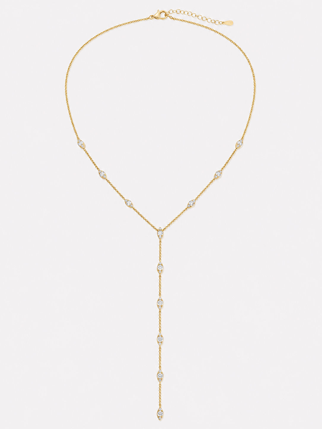 Gold Y lariat necklace with marquise cubic zirconia stations and a delicate drop chain on a light gray background