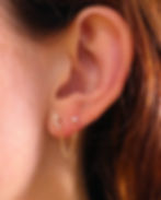 Model wearing a 14K gold double earring with a drop chain. Elegant gold jewelry stacking for multiple piercing