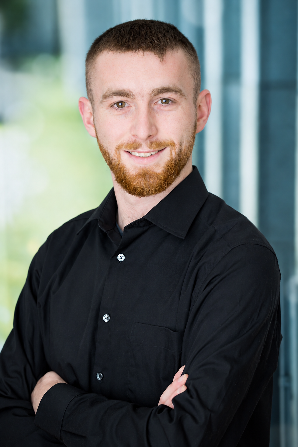 Professionelles Porträt eines lächelnden Geschäftsmanns.png