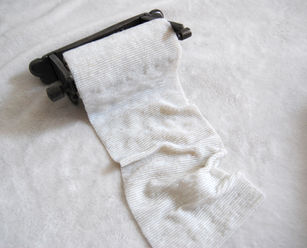 Image of artwork by Kae Sasaki entitled Untitled (Toilet Paper 2), created in  2024. It is a beadwork made with one sheet of thread and reclaimed vintage Japanese beads woven on a custom loom, installed on a found toilet paper holder. The size of artwork is 22.5”X4.25”