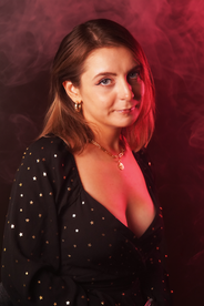 Young woman with blue eyes against a red smoky background, smiling