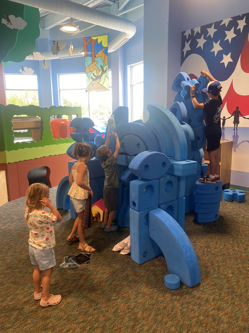 Children playing with large blue blocks.