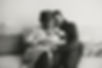 Mother and father holding newborn on couch