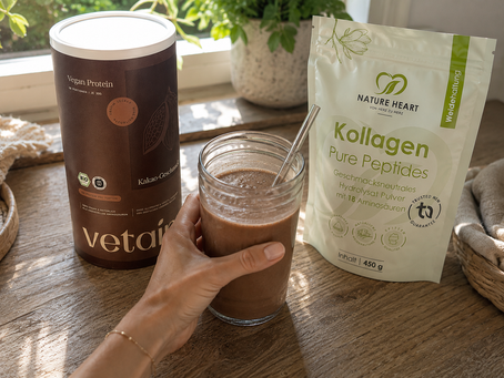 Vetain Vegan Protein Kakao mit Nature Heart Kollagen und fertigem Proteinshake auf einem Holztisch