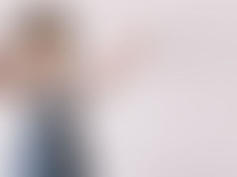 A young toddler boy with arms wide open reaching for a bubble