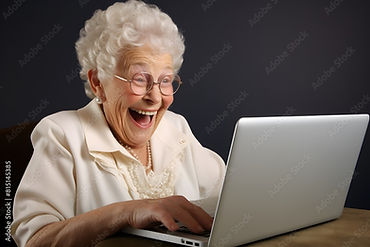 Lachende alte Frau vor dem Computer.