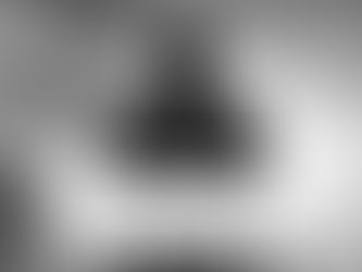 A cinematic, wide-angle shot from behind an England player as they stand on the Wembley turf, facing the vast, illuminated Arch and a capacity crowd. The player is wearing the iconic white Three Lions home shirt, their name and number visible on their back as they look up at the towering stands. The stadium floodlights create a dramatic lens flare, and the atmosphere is captured through a slight motion blur of thousands of waving St. George’s Cross flags in the background. It’s a "hero" shot that emphasizes the scale of international duty and the pride of representing the nation.