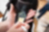 Hands applying hair colour to a woman's head.