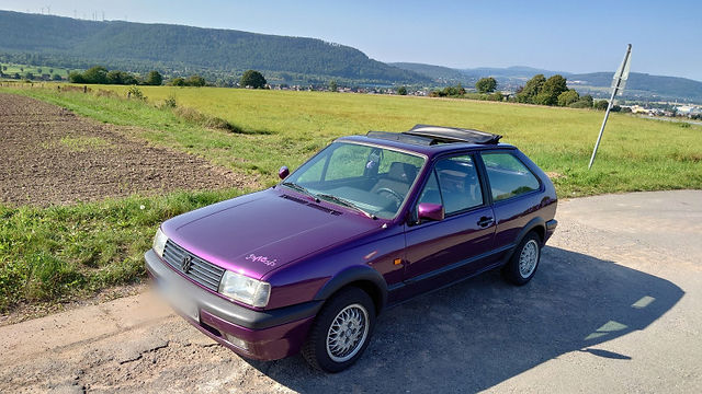 Lila VW Polo Coupé, Sonnenblende, ländliche Kulisse