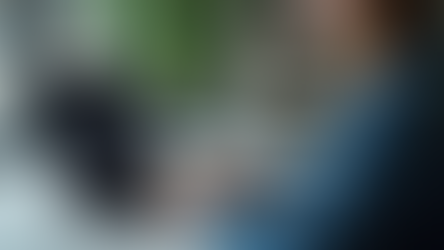 girl on laptop typing code for SEO, wearing a blue jacket on a table in home office.