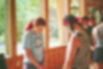 Girls bow their heads in prayer during a summer camp session.