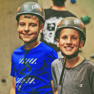 Two boys getting ready for climbing wall.