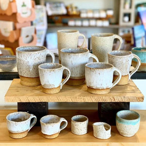 Many sizes of stoneware mugs and cups with handles.  Speckled buff clay with granny's white glaze. 