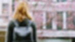  A millennial woman who struggles with people-pleasing looks on at a building.