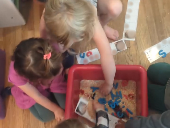 Children learning about letters with a sensory activity.
