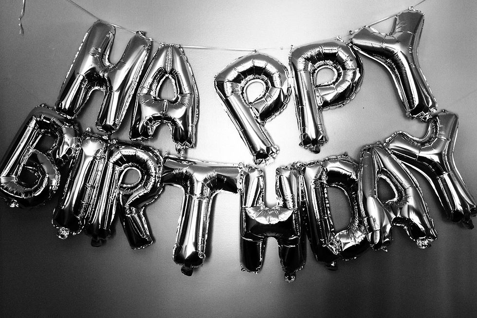 Black and white photo of metallic Happy Birthday balloons for a birthday party celebration