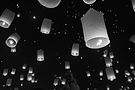 Many glowing sky lanterns in the dark night sky