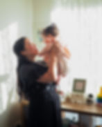 Mother and baby hugging closely in a nursery, captured in soft late afternoon light