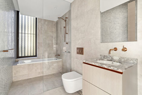Contemporary luxury bathroom designed by 3Xi Studio featuring natural stone finishes, custom marble vanity, brushed copper tapware, frameless glass shower, and refined residential interior design.