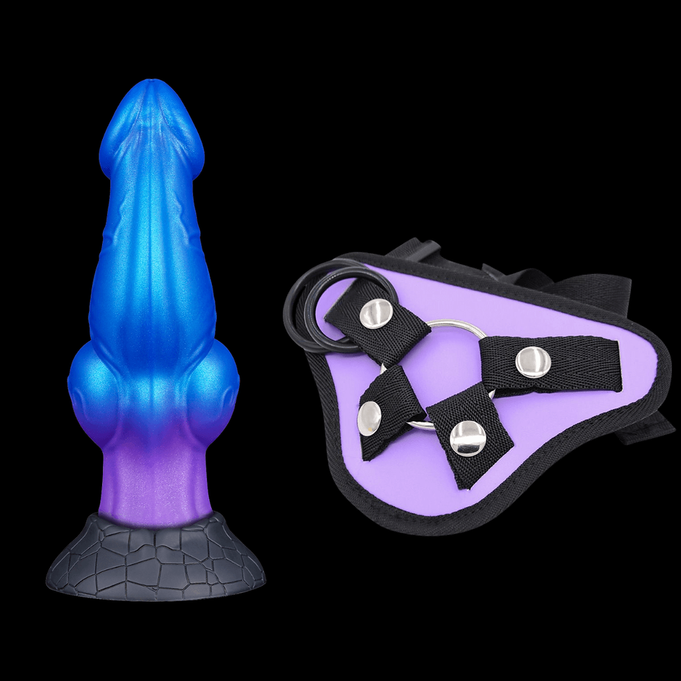Blue and purple silicone dildo with textured base next to a black and lavender strap-on harness on a black background.