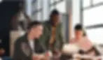 Three people collaborating on a laptop