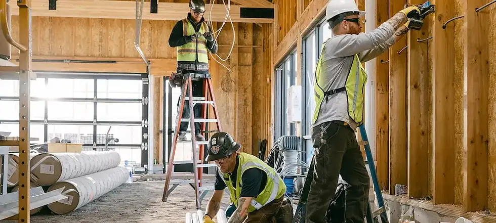 Three construction workers building a structure