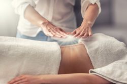 esoteric-healing-by-hands-of-standing-therapist-creating-light-above-young-woman-lying-on-