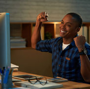 Young man celebrating success at computer