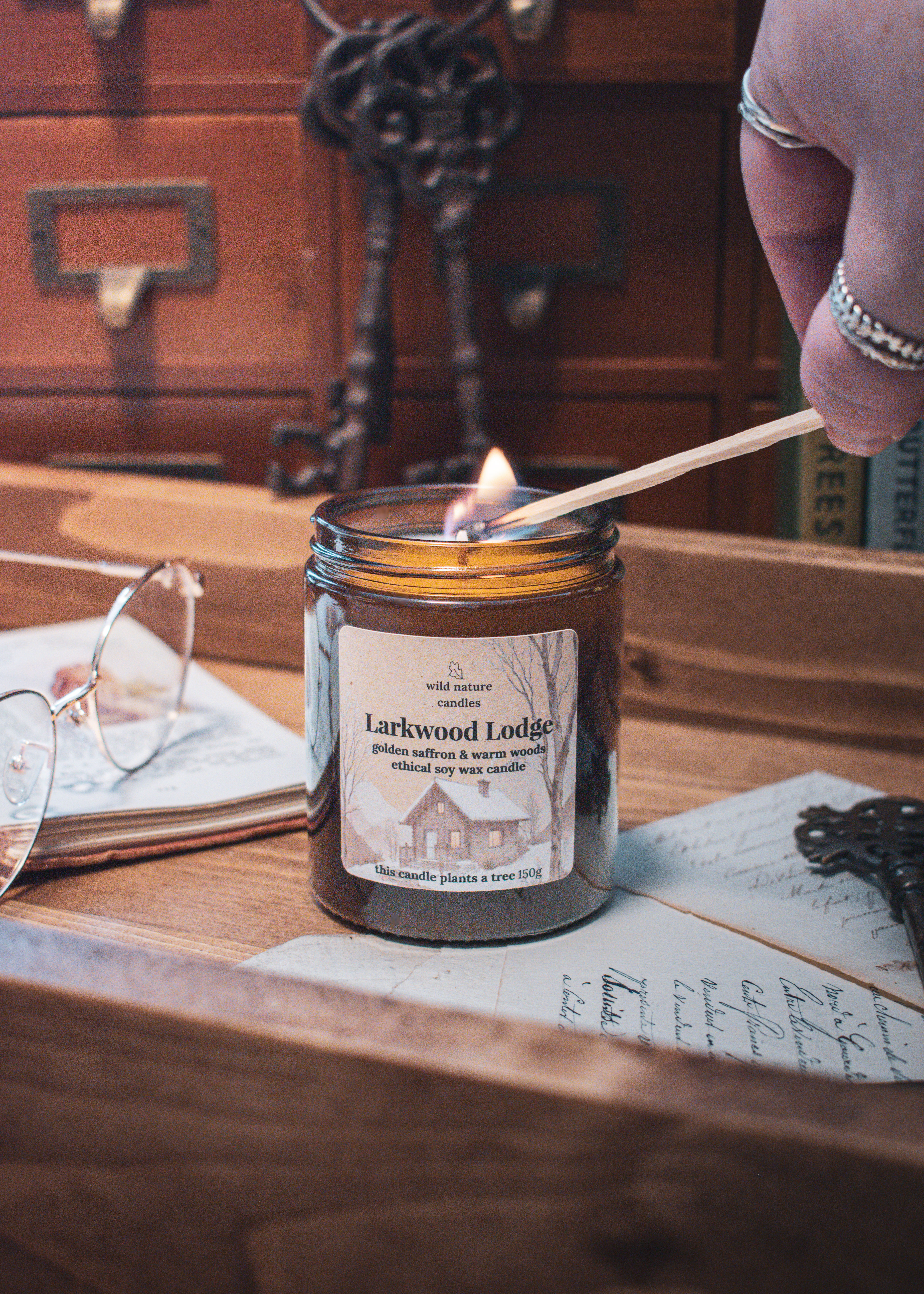 Larkwood Lodge soy candle glowing with a warm flame in a cosy setting