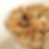 Chunky clusters of vanilla-sweet granola piled in a jar with visible seeds and oats.