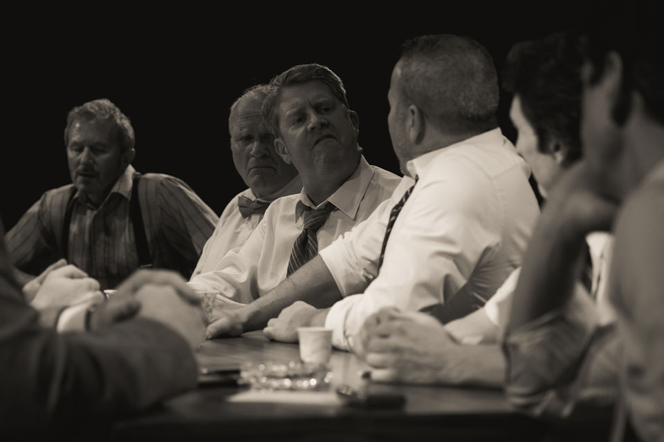An image from the play 12 Angry Men. Two jurors appear to be speaking to one another.