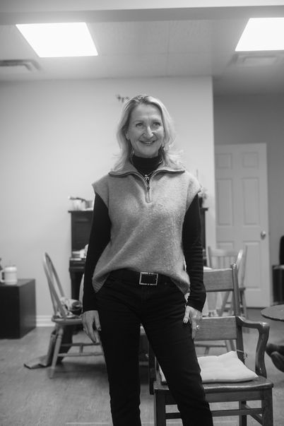 An image from rehearsals for the play "Vanya and Sonia and Masha and Spike". A female actor (Masha) is standing confidently and looking off-camera with a smile on her face.