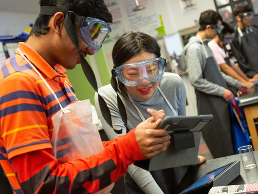 High school students read their lab directions on a computer tablet during AP chemistry class.