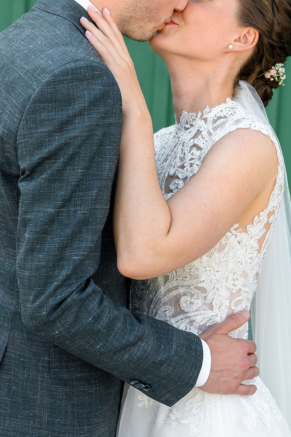 cropped shot of bride and groom kissing