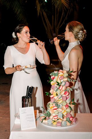 Brautpaar trinkt Sekt im Vordergrund Hochzeitstorte