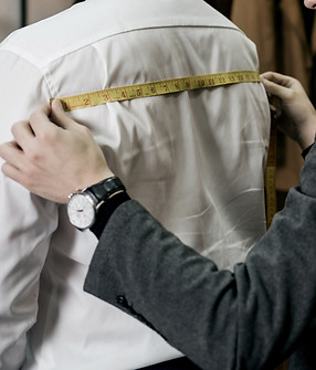 Tailor standing near male client measuring back. Tailor man taking measures for new busine