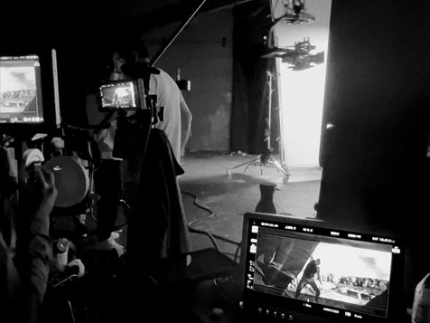 Black and white photo of a film set with stage lighting equipment and camera monitoring setup, Toyota bZ4X virtual production