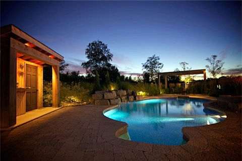pool at night with landscape lighting