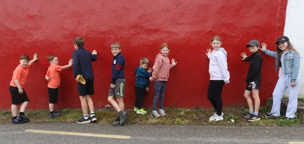 Some of the kids laying their hand on the wall of Jamsie O'Sullivan's Pub in Fairhill