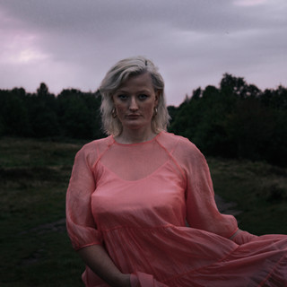Portrait of a woman in pink dress in a park