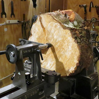 Birch Root Slab secured with a rotating center on Stubby 1000 Lathe tail stock.