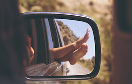 Feet relaxing out a car window