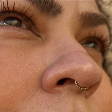 gold septum piercing on a woman pierced at paramount tattoo