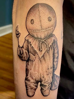 Black and gray scarecrow-inspired horror tattoo with stitched details and textured shading by Fort Worth tattoo artist