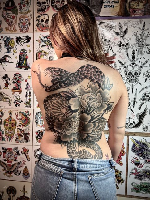 Large back piece tattoo in black and gray of a snake