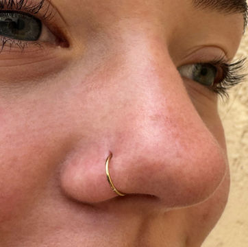 a cute nose ring in solid gold on a woman