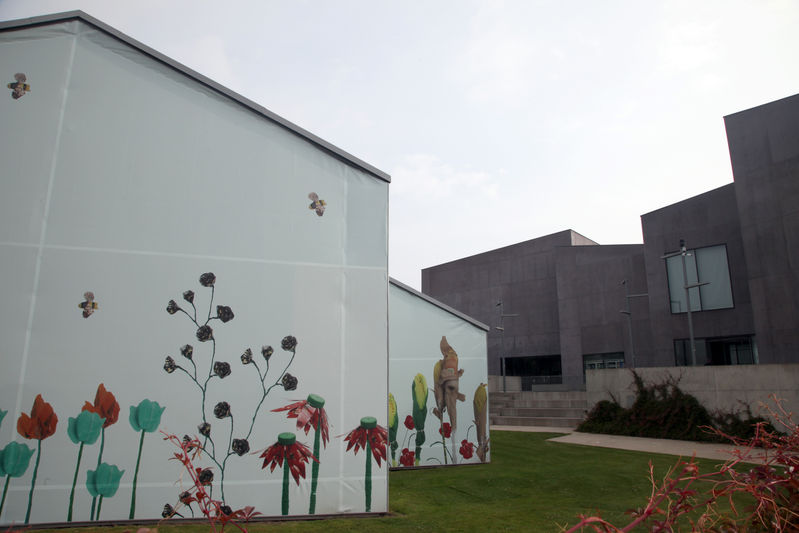 Building wrap decorate with plastic flower sculptures with the Hepworth Gallery in the background
