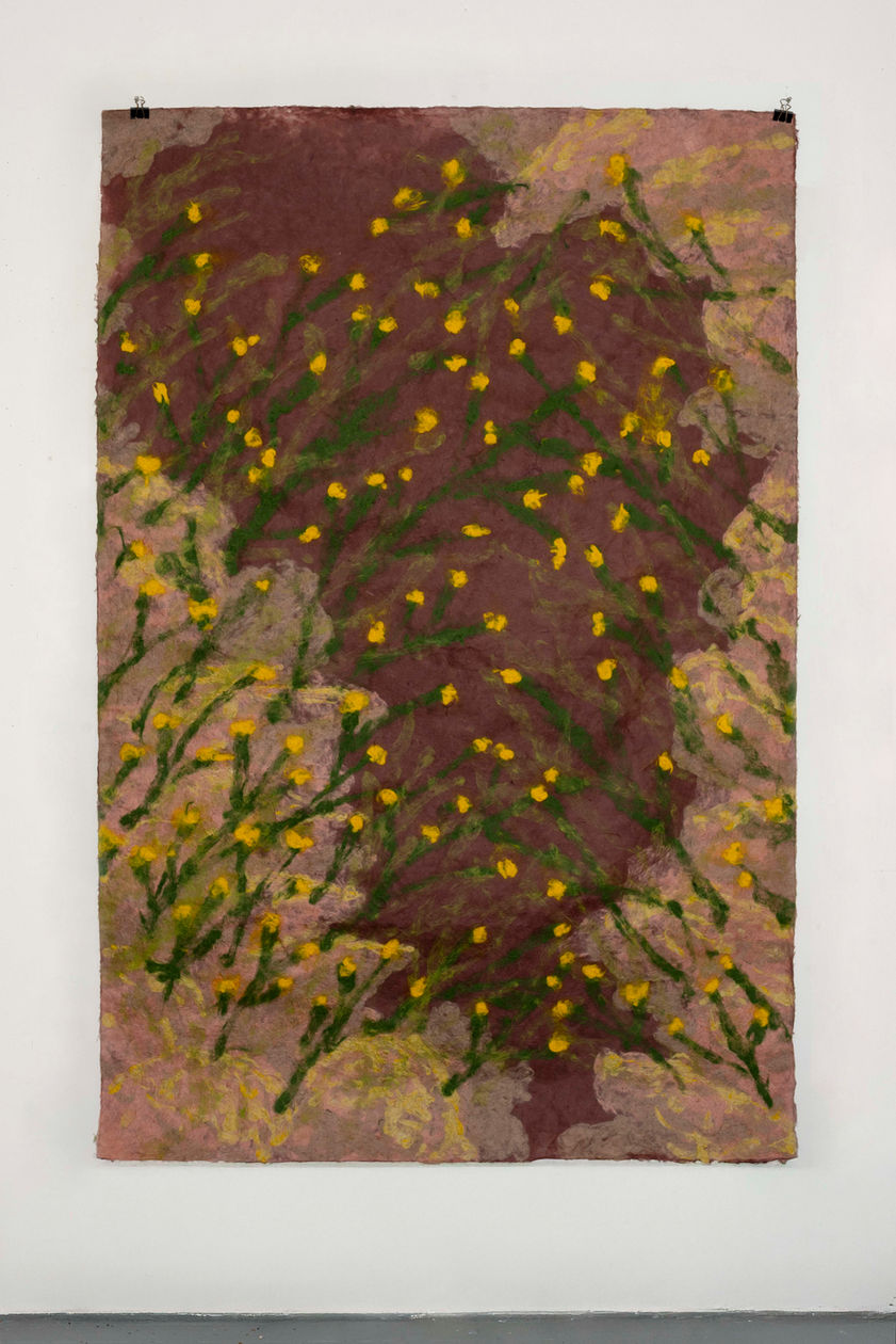 Paper pulp gathers in water like memory before it becomes form. Mulberry fibers drift and tangle, pale and tensile, carrying a quiet strength. Pigment seeps into the mixture, not sitting on the surface but entering the body of the sheet itself. The image is formed from within—like history—embedded rather than illustrated.

As the pulp settles into the mold, landscapes begin to surface. Hints of hills rise through thicker deposits of fiber; lighter washes dissolve into sky. Colors recall sunburned earth, olive leaves, sea light, dust after wind. The material holds the sensation of heat and dryness, of walking barefoot on soil, of shade gathered beneath a tree. Childhood appears not as a fixed narrative but as atmosphere: the echo of voices carried across an open field, the geometry of stone houses, the rhythm of seasons shifting from green to gold.

The fibers intertwine like roots beneath the ground, binding fragments of personal and collective memory. Mulberry becomes both fragile and resilient, much like the act of remembering itself. The surface buckles and rises in subtle relief, suggesting terrain shaped by time—valleys of absence, ridges of presence. Pigment pools in certain areas, staining them more deeply, like moments that refuse to fade.

In these pulp paintings, nature and childhood history are inseparable. The land is not a backdrop but a participant—absorbing stories, holding traces of movement, carrying both tenderness and tension. The sheet becomes a field where past and present coexist, where fiber and soil, memory and landscape, merge into one quiet, breathing surface.